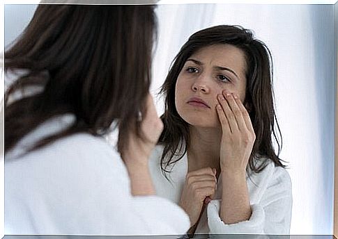 the girl looks at herself in the mirror